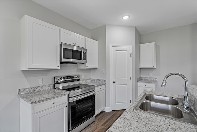 kitchen featuring white cabinets, sink, stainless steel appliances, and dark wood-type flooring