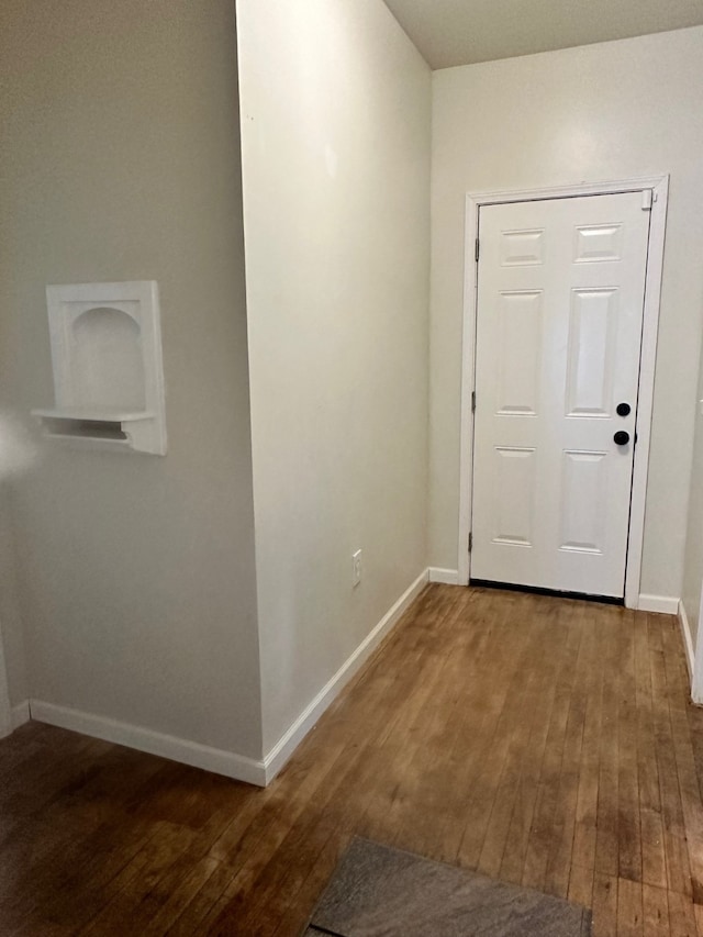 corridor with hardwood / wood-style flooring