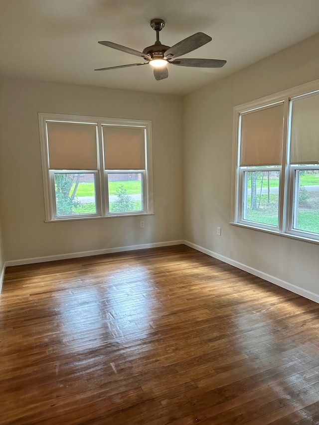 empty room with dark hardwood / wood-style floors and ceiling fan