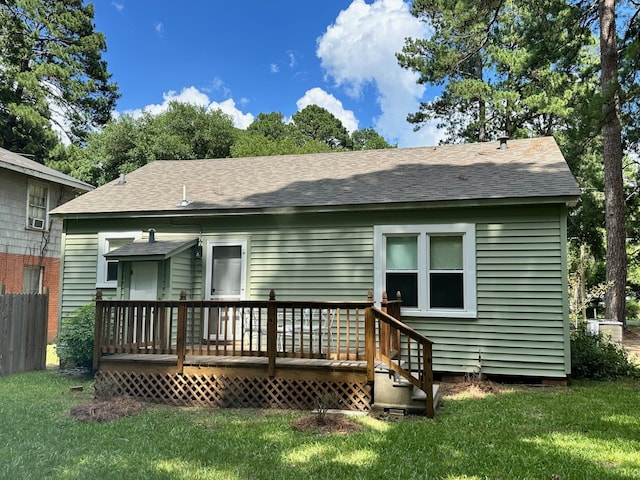 rear view of house with a wooden deck and a lawn