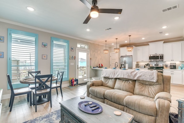 living room with ceiling fan, light hardwood / wood-style floors, and ornamental molding