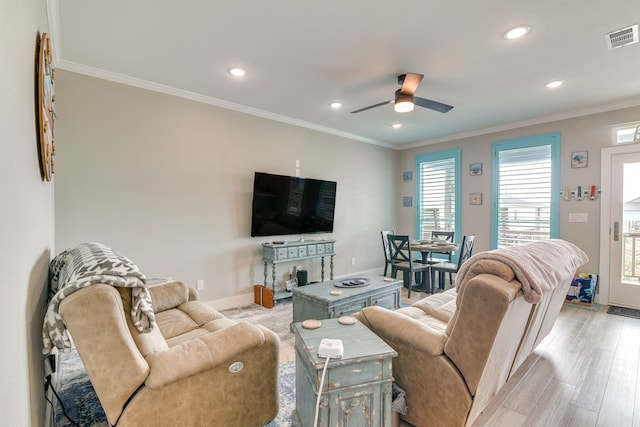 living room with light hardwood / wood-style floors, plenty of natural light, ceiling fan, and crown molding