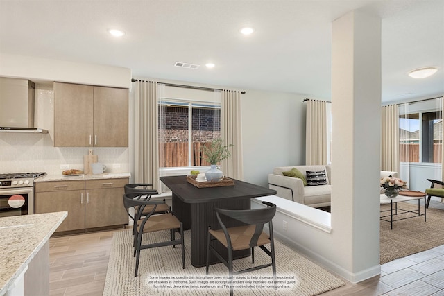 dining space with light hardwood / wood-style floors and a healthy amount of sunlight