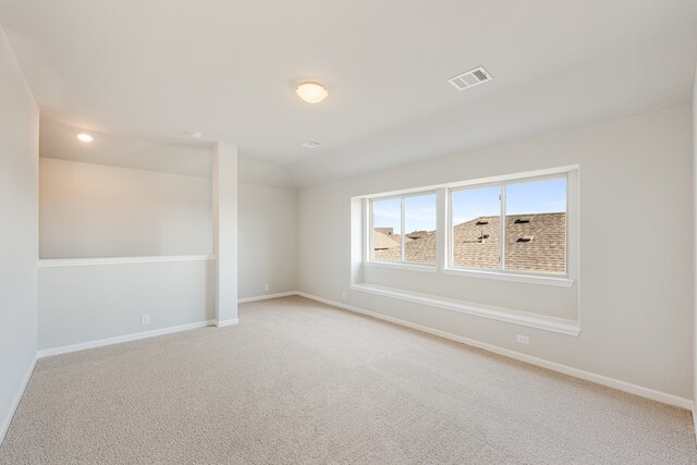 spare room featuring light carpet