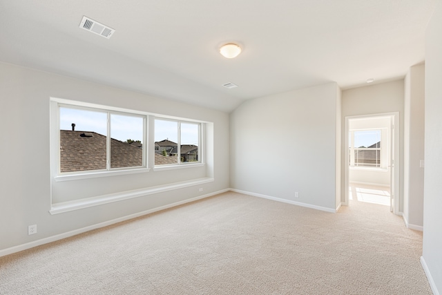 empty room featuring lofted ceiling and light colored carpet