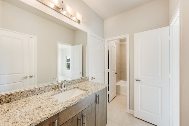 bathroom with vanity, tile patterned flooring, and tiled shower / bath