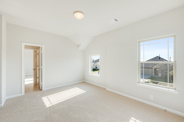 unfurnished bedroom featuring light colored carpet and lofted ceiling