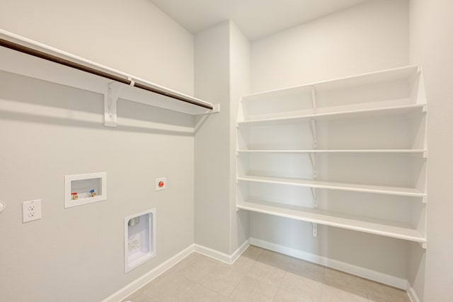 laundry area featuring electric dryer hookup, light tile patterned floors, and washer hookup