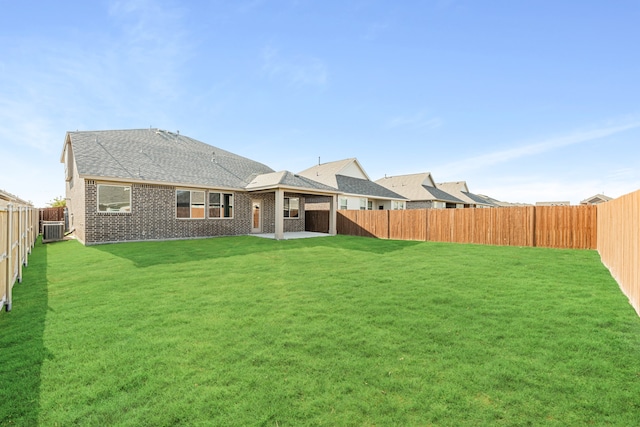 rear view of property with central air condition unit, a patio area, and a lawn