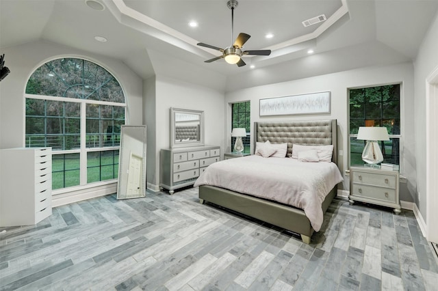 bedroom with ceiling fan, light hardwood / wood-style floors, and vaulted ceiling