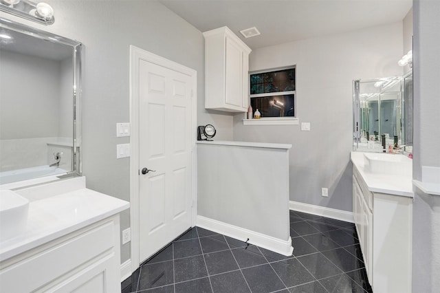 bathroom featuring vanity, tile patterned floors, and a tub