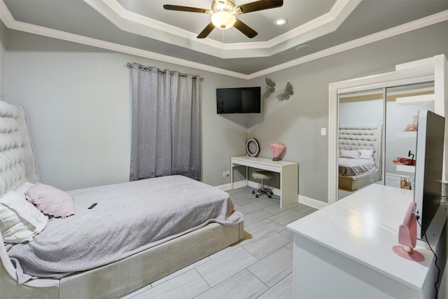 bedroom featuring a tray ceiling, ceiling fan, and ornamental molding