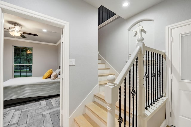 stairs featuring hardwood / wood-style flooring, ceiling fan, and crown molding