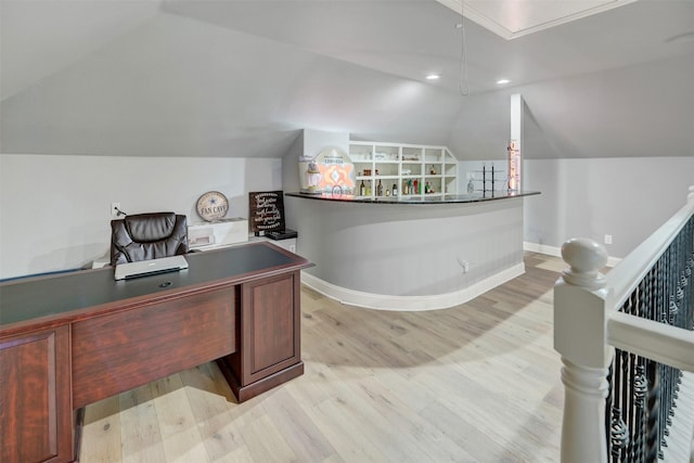 home office featuring vaulted ceiling and light hardwood / wood-style flooring