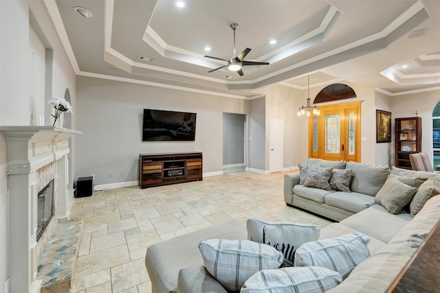 living room with ceiling fan with notable chandelier, a raised ceiling, and crown molding