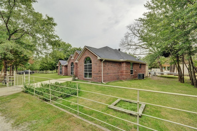 view of side of property with a yard and cooling unit