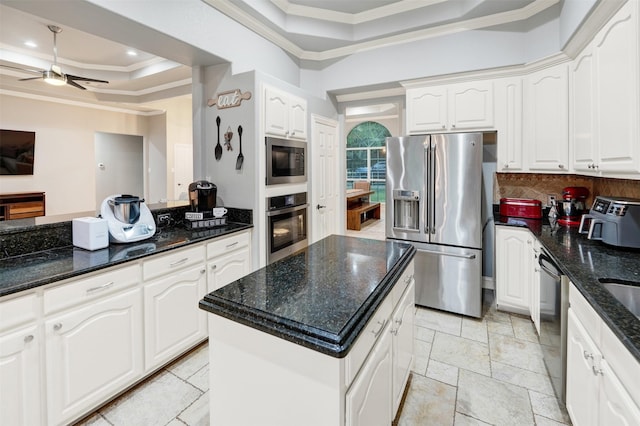 kitchen featuring a center island, dark stone countertops, crown molding, white cabinets, and appliances with stainless steel finishes