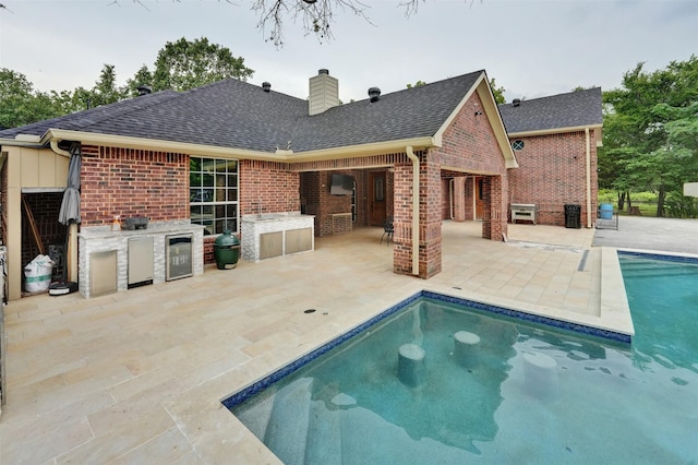 rear view of house featuring area for grilling, a patio area, and beverage cooler