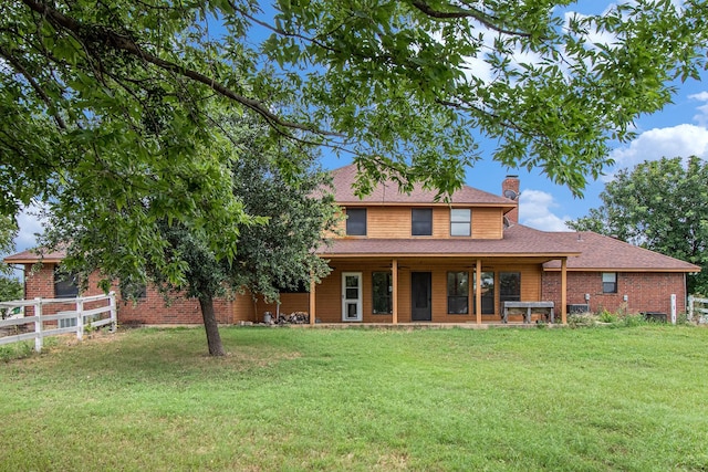 rear view of property with a lawn