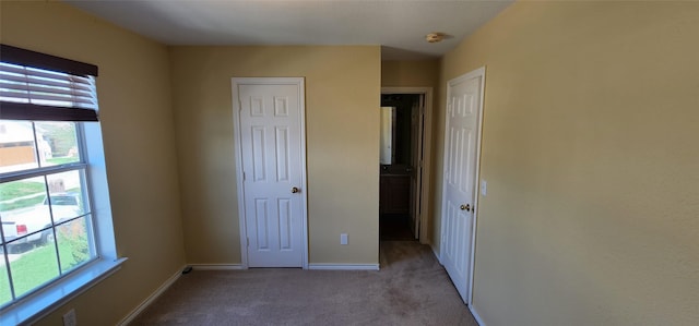 unfurnished bedroom featuring light carpet