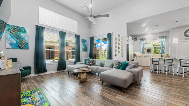 living room with ceiling fan and a towering ceiling