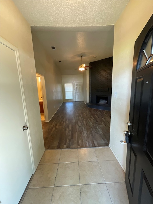 corridor with light hardwood / wood-style flooring and a textured ceiling