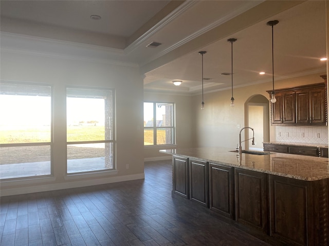 kitchen featuring crown molding, dark brown cabinets, backsplash, pendant lighting, and sink