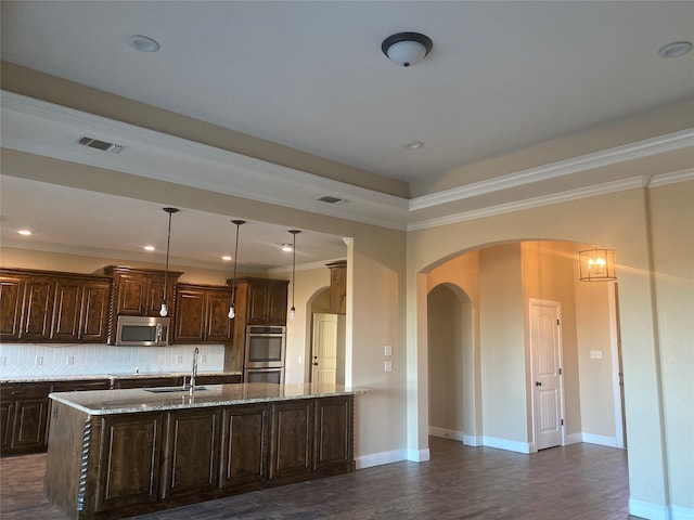 kitchen featuring stainless steel appliances, dark hardwood / wood-style flooring, light stone counters, and tasteful backsplash