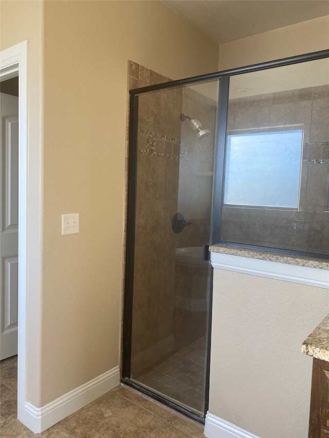 bathroom featuring a shower with shower door, vanity, and tile floors