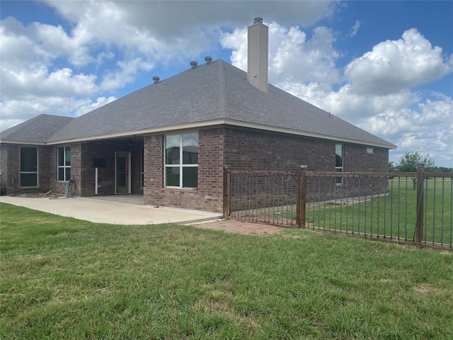 rear view of house with a patio and a yard