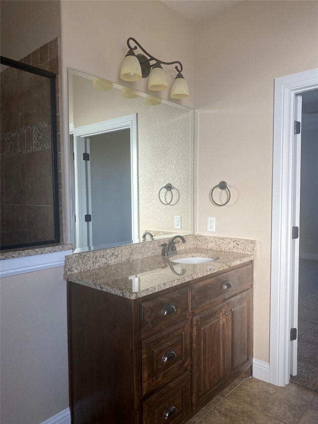 bathroom with vanity, tile floors, and a shower with door