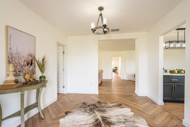 dining space with light parquet flooring and a notable chandelier