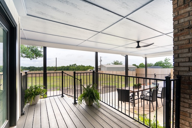 wooden terrace with ceiling fan and a lawn