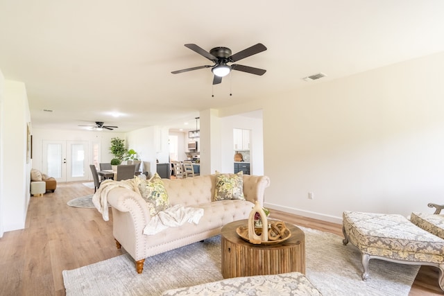 living room featuring ceiling fan and light wood-type flooring