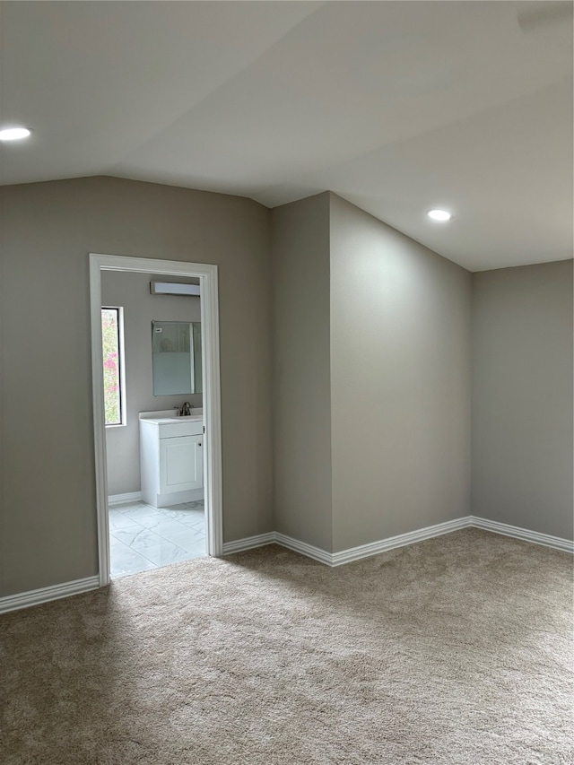 spare room featuring sink, lofted ceiling, and light colored carpet