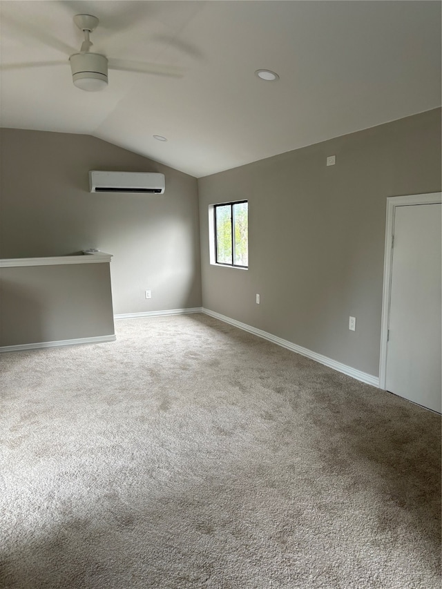 empty room with an AC wall unit, carpet, ceiling fan, and vaulted ceiling