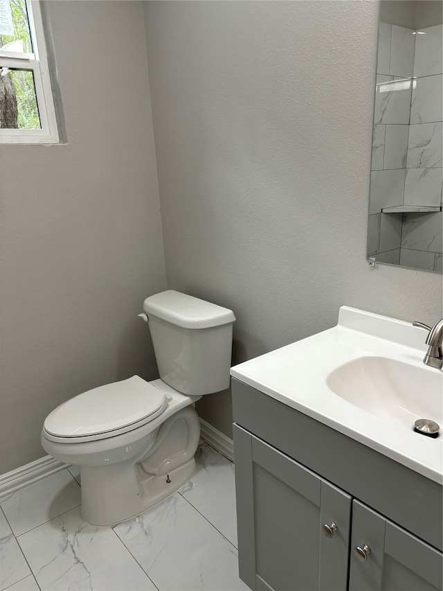 bathroom with tile flooring, vanity, and toilet