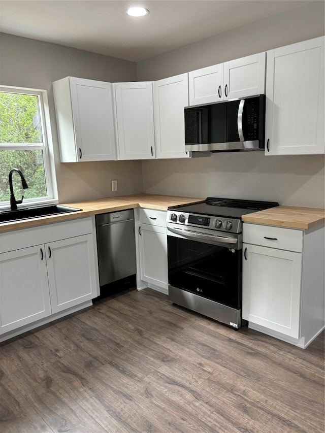 kitchen with stainless steel appliances, wood-type flooring, sink, and white cabinetry