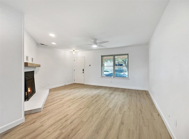 unfurnished living room featuring light hardwood / wood-style flooring and ceiling fan