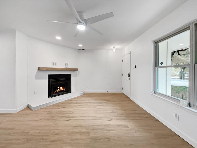 unfurnished living room featuring ceiling fan and light hardwood / wood-style floors