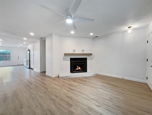 unfurnished living room featuring hardwood / wood-style flooring and ceiling fan