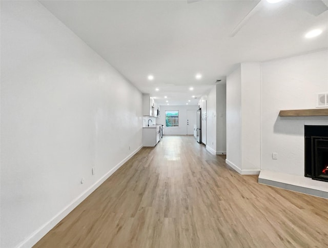 unfurnished living room with light hardwood / wood-style floors and sink