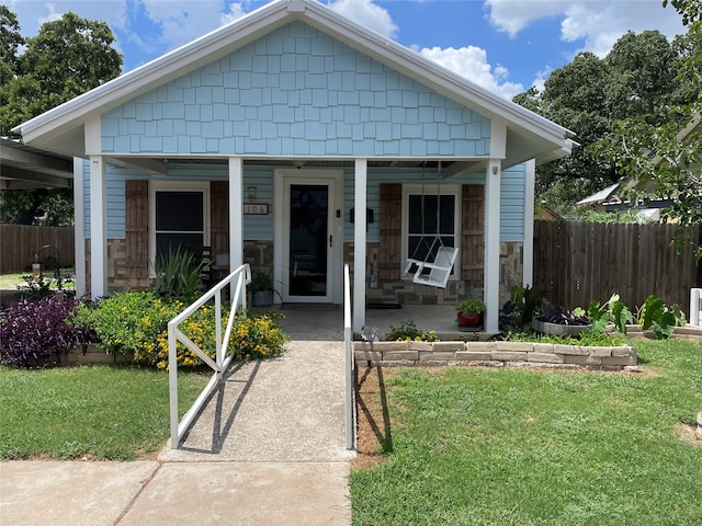 bungalow-style home with covered porch and a front lawn