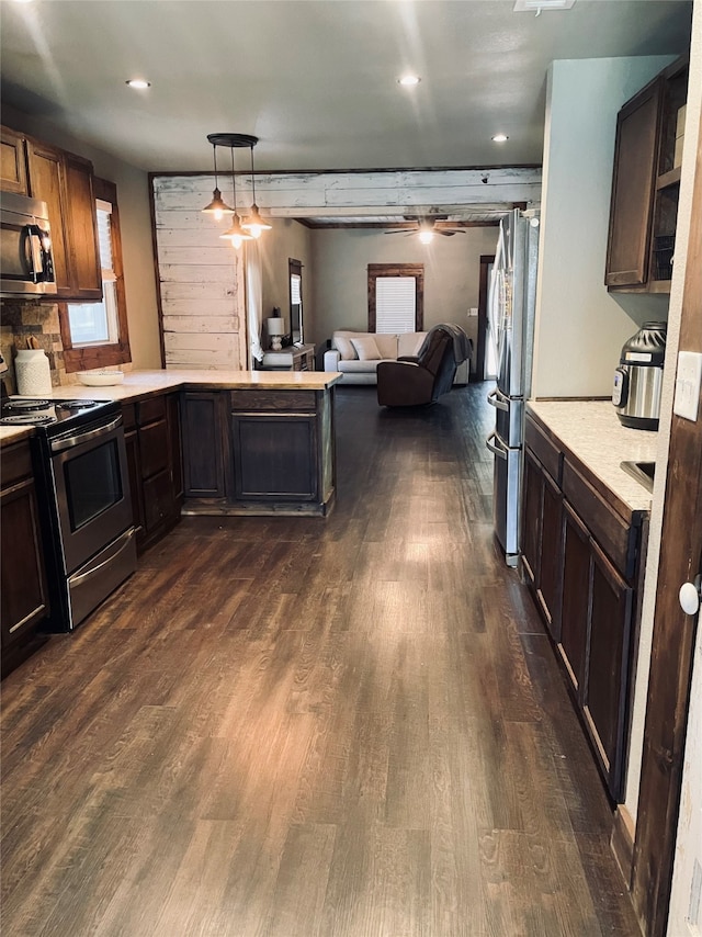 kitchen featuring decorative light fixtures, appliances with stainless steel finishes, beam ceiling, tasteful backsplash, and dark wood-type flooring