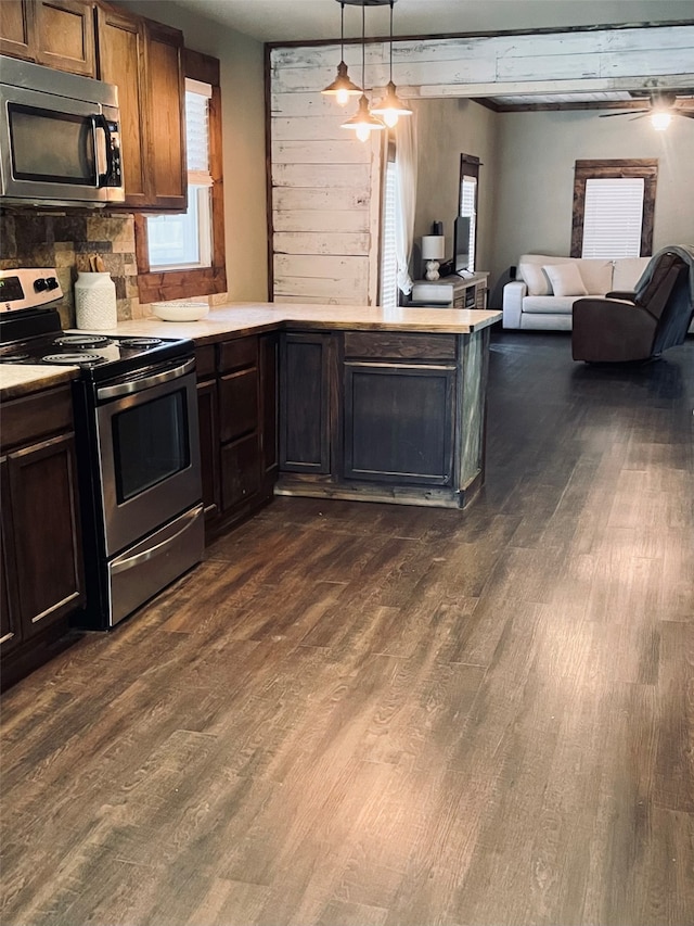 kitchen with a healthy amount of sunlight, decorative light fixtures, stainless steel appliances, and dark hardwood / wood-style floors