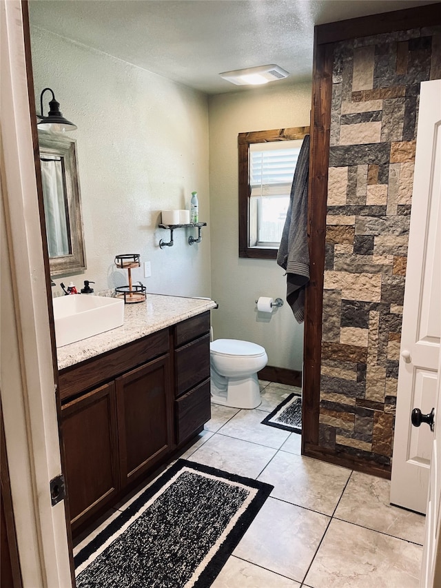 bathroom featuring toilet, walk in shower, tile patterned flooring, vanity, and a textured ceiling