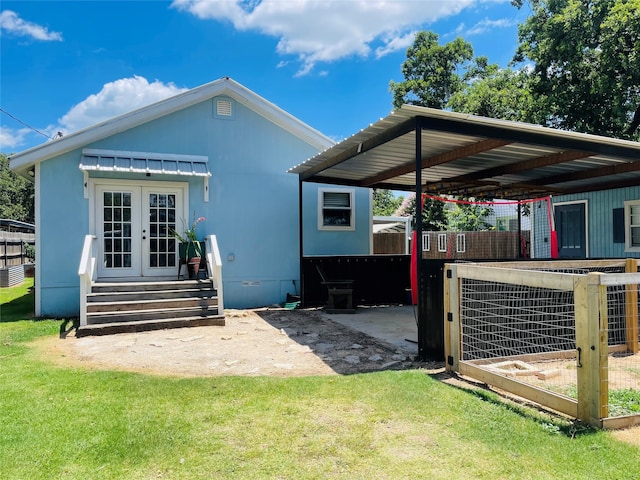 rear view of property featuring a yard and a carport