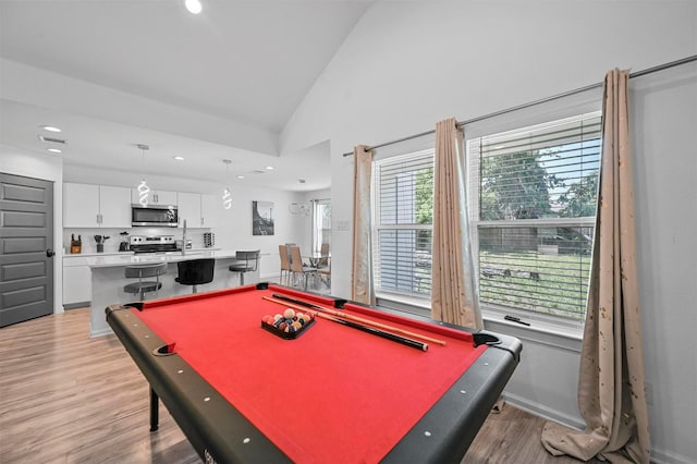 game room featuring light hardwood / wood-style flooring, high vaulted ceiling, plenty of natural light, and billiards