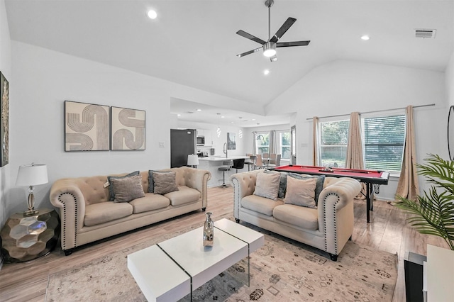 living room with billiards, high vaulted ceiling, and light hardwood / wood-style flooring