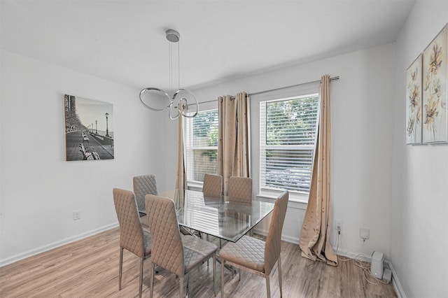 dining area featuring light hardwood / wood-style floors and a notable chandelier